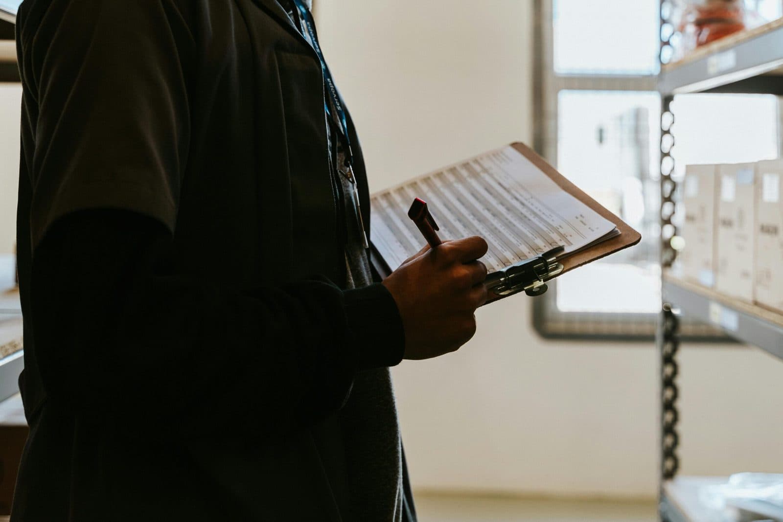 A person reviewing a checklist on a clipboard in a warehouse